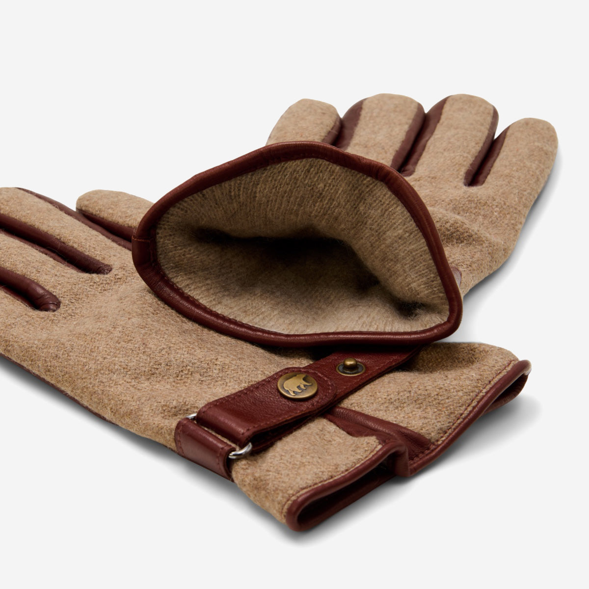 Pair of brown gloves with leather accents on a white background