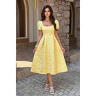 Model wearing yellow jacquard puff sleeve midi dress with square neckline and full skirt.

