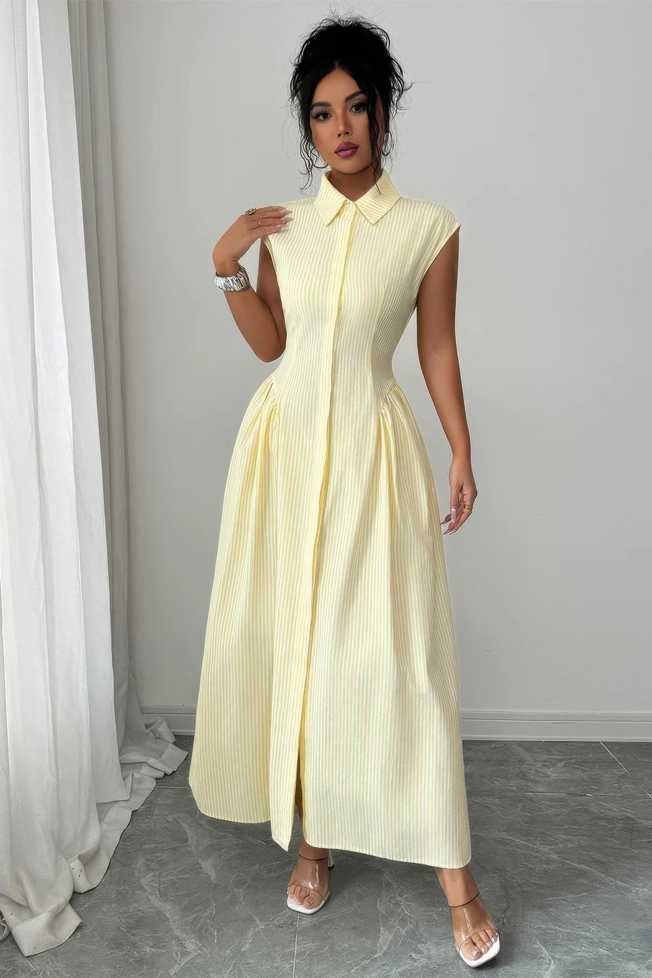 Woman wearing the Limoncello Lane Collared Midi Dress in pale yellow with a textured stripe, pointed collar, cap sleeves, defined waist, and full midi skirt.