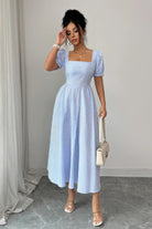 Model wearing blue and white striped puff sleeve midi dress with square neckline and full midi skirt.
