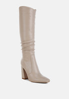Angled front view of beige Vienna Sculpted Heel Knee High Boots featuring smooth faux leather, tall shaft and high block heel.