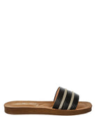 Side profile of black sandals highlighting sleek faux leather and slip-on ease.