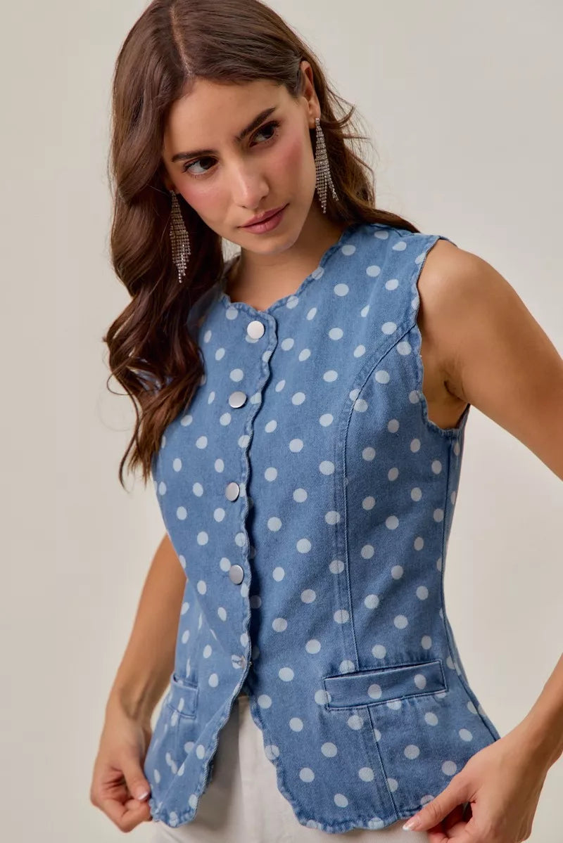 Close up of blue denim vest with white polka dots and scalloped trim
