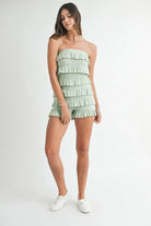 Model wearing sage green pointelle knit romper with layered ruffles
