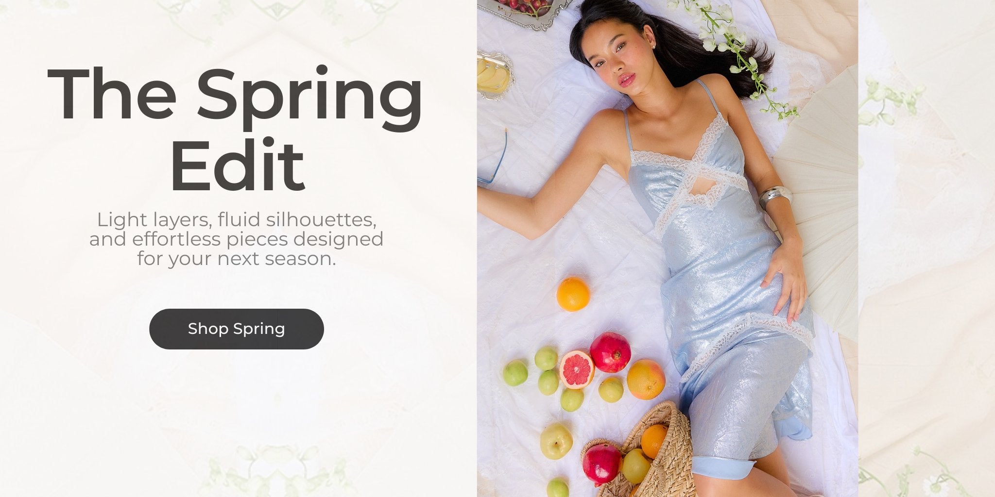 Spring Edit collection featuring light blue lace trim midi dress styled with fresh fruit and woven straw bag