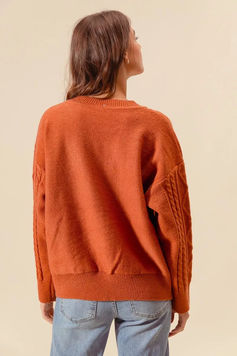 Back view of Copper Meadow Floral Knit Sweater in rust orange with dropped shoulders and ribbed hem.