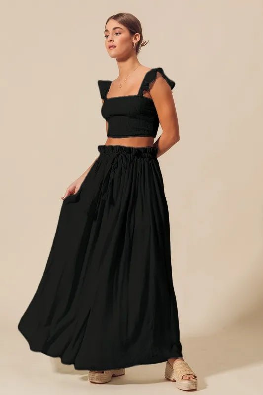 Side view of black two piece summer skirt set with ruffle straps
