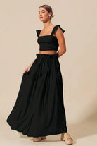 Side view of black two piece summer skirt set with ruffle straps
