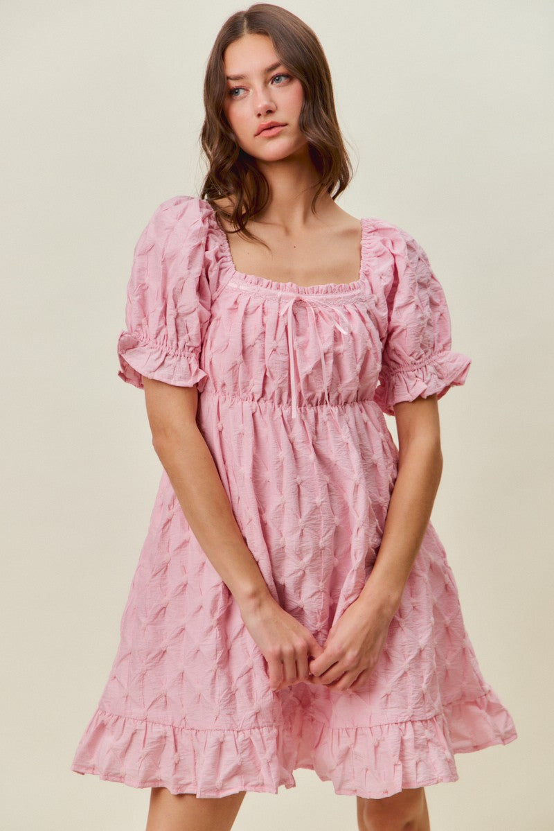 Front view of the Everly Textured Puff Sleeve Dress featuring a square neckline, puff sleeves, textured fabric, babydoll silhouette, and ruffle hem.