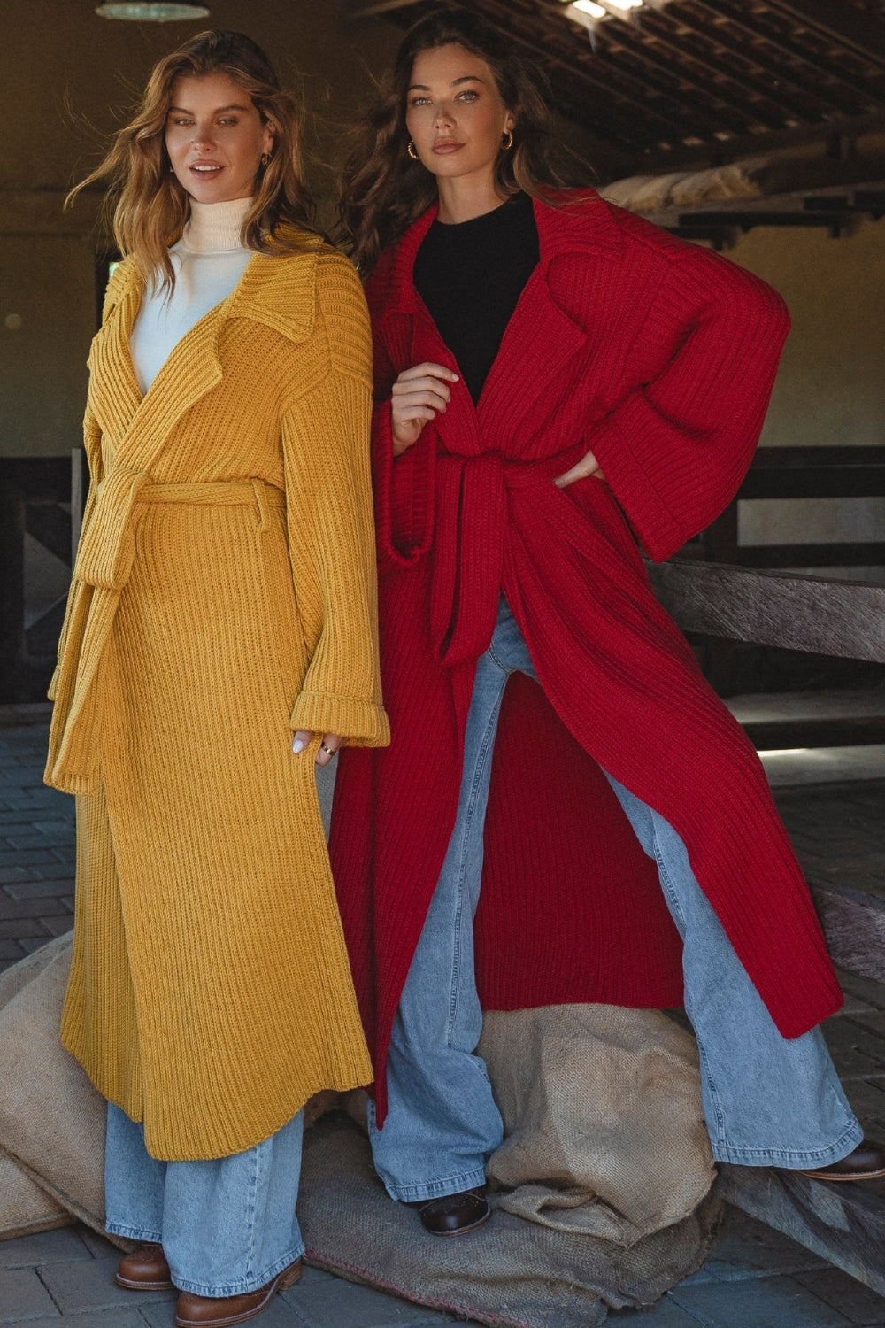 Two women wearing mustard yellow and red Bali ELF long knit cardigans