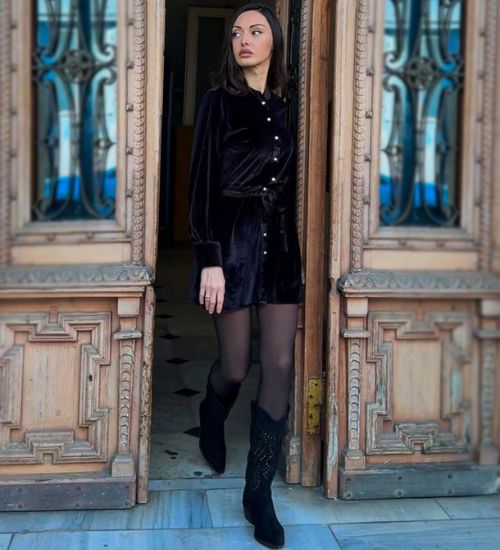 Black velvet mini dress paired with chic black knee-high boots, from AVAH Collections