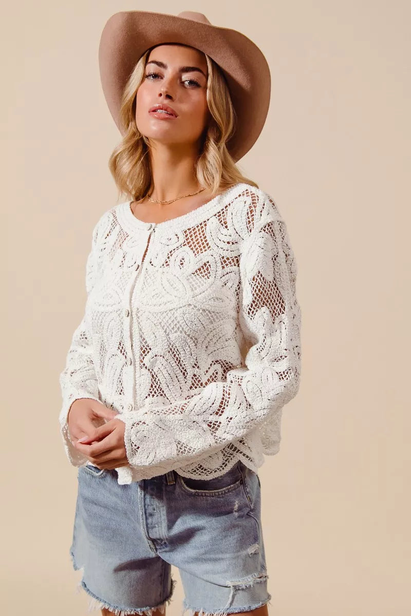 Model wearing ivory lace knit cardigan with denim shorts and gold jewelry
