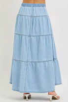 Back view of tiered light wash denim maxi skirt with elastic waistband
