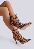 Leopard print boots worn by a model on a light gray background