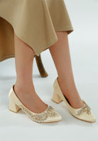 Beige satin block heels shown from front angle on model
