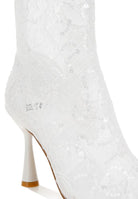 Close-up of white sheer lace ankle boot with sequin detailing

