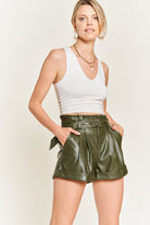 Front view of olive vegan leather shorts styled with a white tank