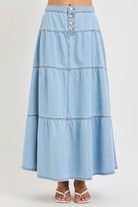 Front view of light blue tiered denim maxi skirt with button front detail
