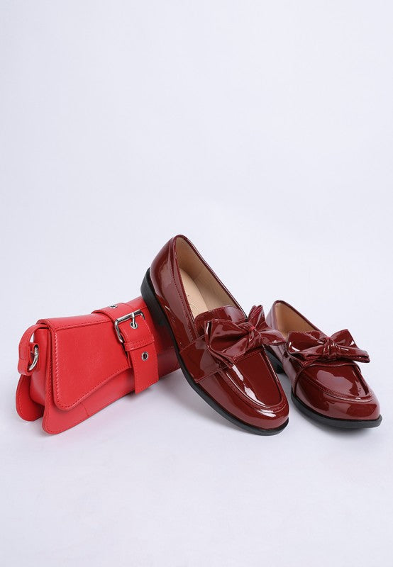 wine red patent loafers with matching red bow and bag
