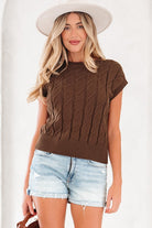 Full front view of brown sleeveless knit top on model wearing white hat and denim shorts.
