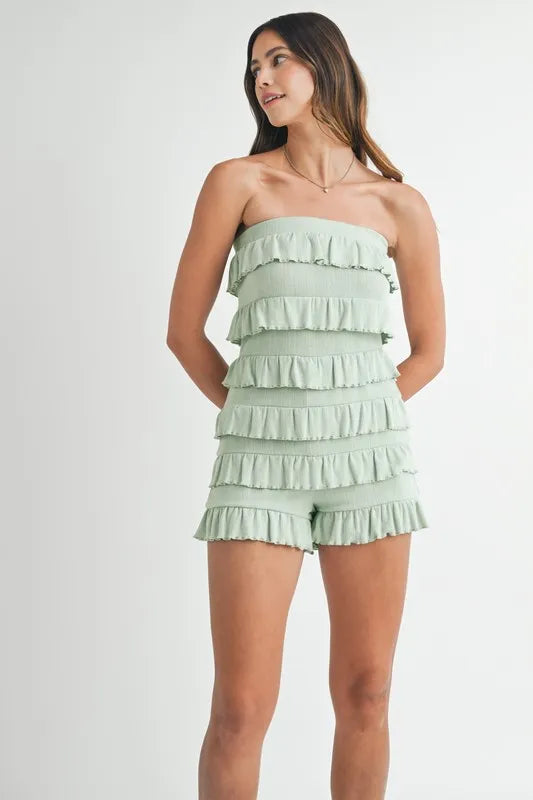 Front view of sage green strapless ruffle romper
