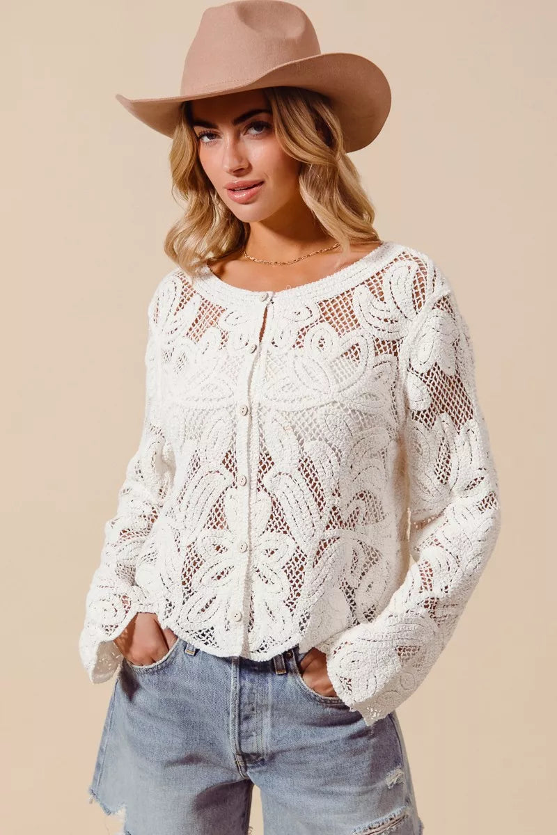 Woman wearing ivory crochet knit cardigan with button front and denim shorts front view
