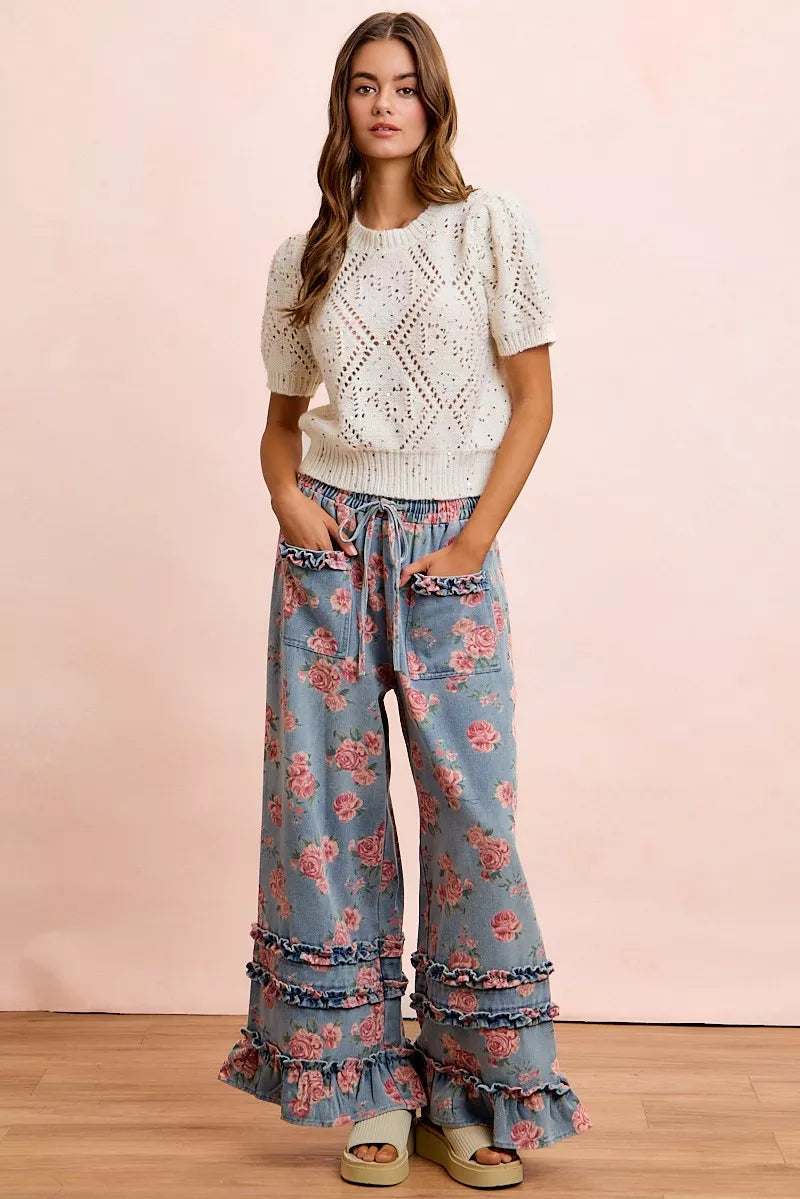 Front view of blue vintage floral wide leg pants with ruffle pocket trim and layered ruffle details.
