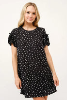 Model wearing a black polka dot shift dress with floral sleeve details and relaxed silhouette | AVAH Collections
