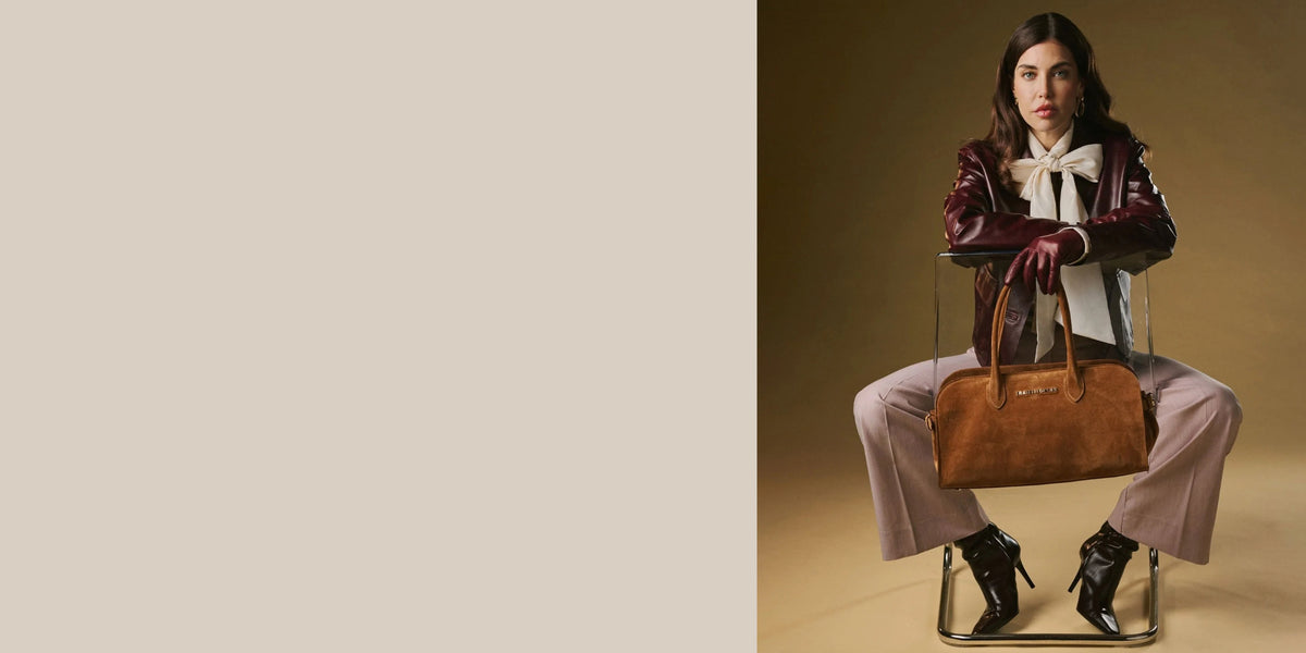 Model wearing burgundy leather gloves and jacket with a brown Fratelli Orsini handbag