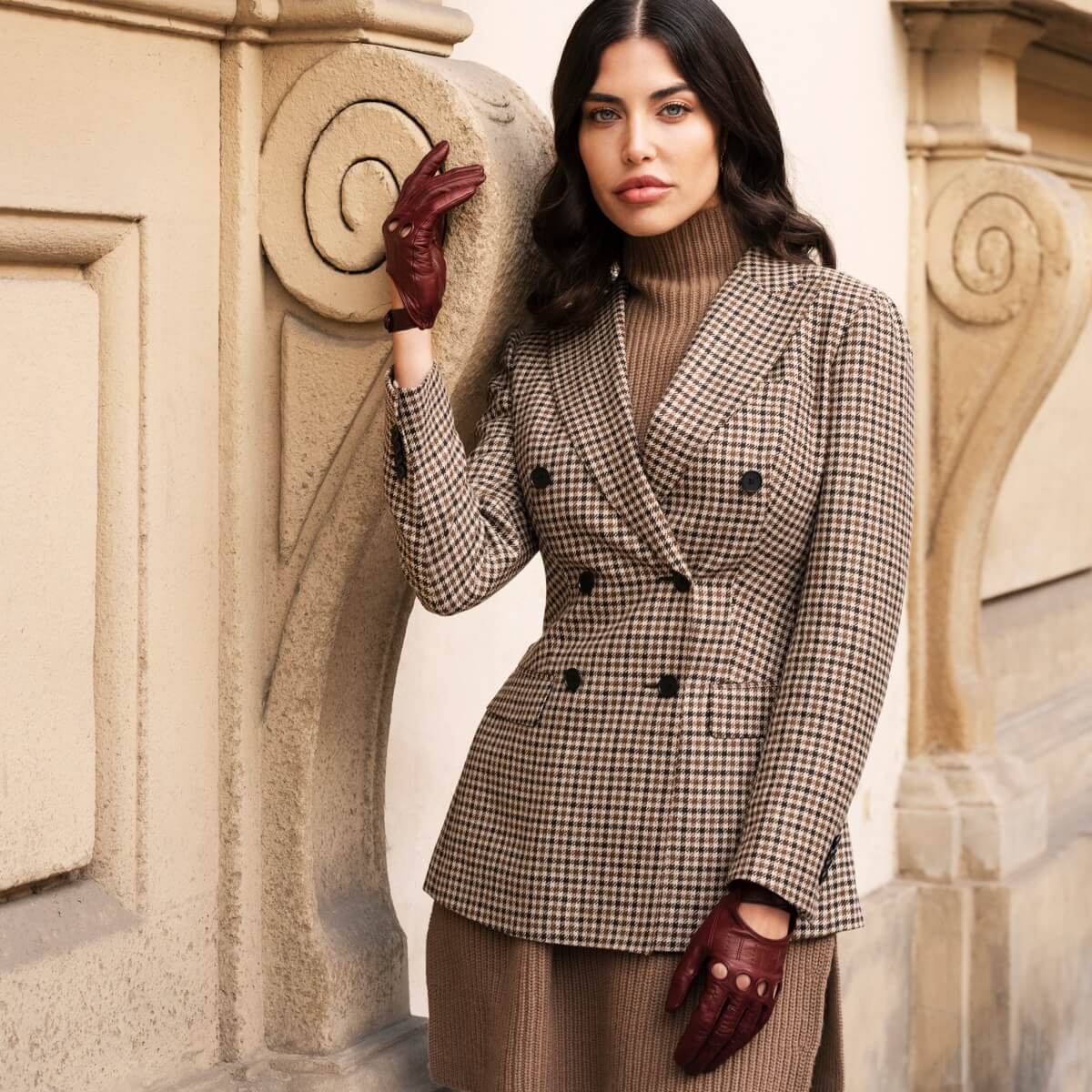 Model wearing burgundy Fratelli Orsini Italian leather gloves with a checked blazer