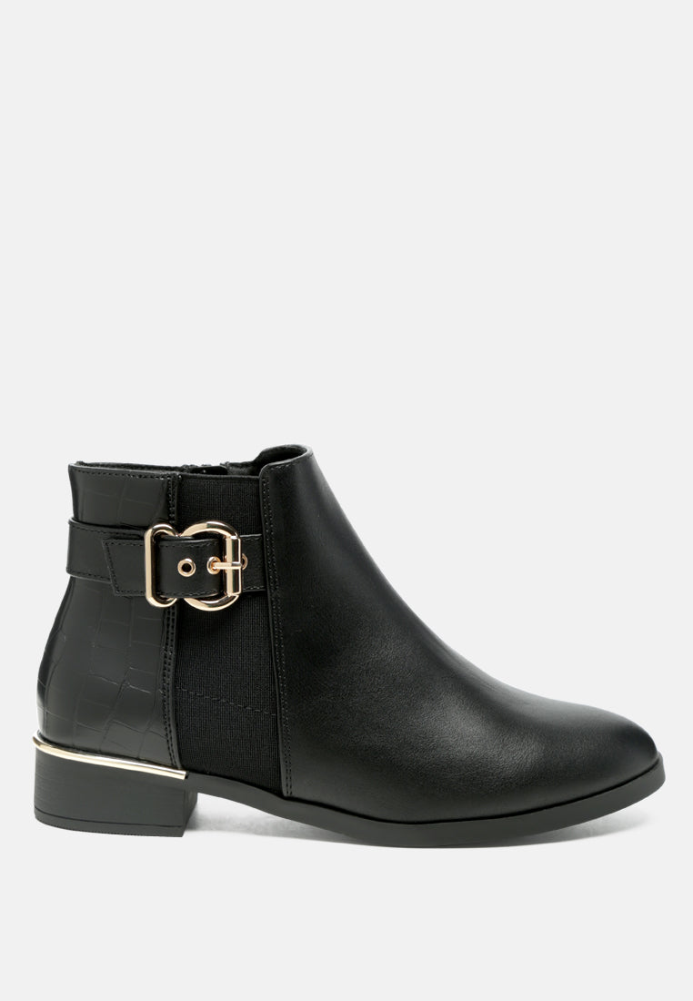 Black ankle boot with a gold buckle on a white background