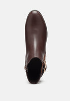 Brown leather boot with a buckle on a white background