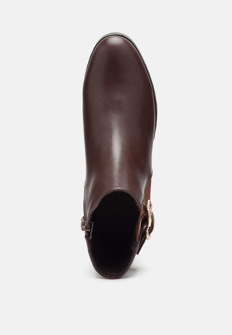 Brown leather boot with a buckle on a white background