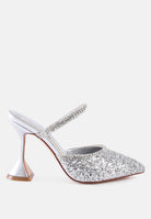 Silver glitter mules with rhinestone embellishment, sculpted heel, pointed toe and crystal decorated elastic strap Side view