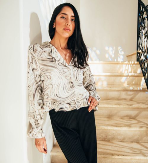 Elegant marble print blouse with long sleeves and pinstripe pants, styled by AVAH