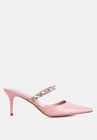 Pink mid-heeled shoe with a decorative diamante strap across the top on a light blue background, side view