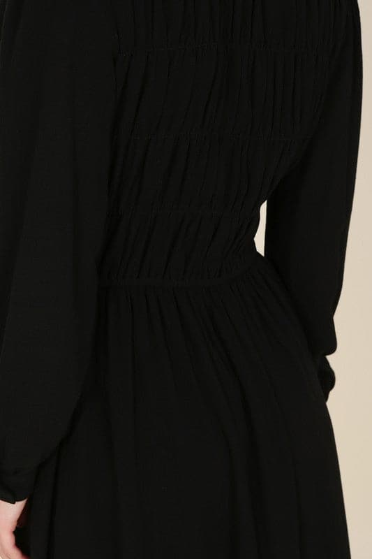 This beautiful midi dresses has four tiers of elastic bands at the bodice which creates a lovely ruched effect. This design gives it an elegant and feminine appearance. The All Dressed Up Ruched Midi Dress has a boat neckline, long sleeves with button at each cuff and below the knee length for easy transition into fall. Wear it with heels and a clutch bag for a chic look. This dress is lined.  