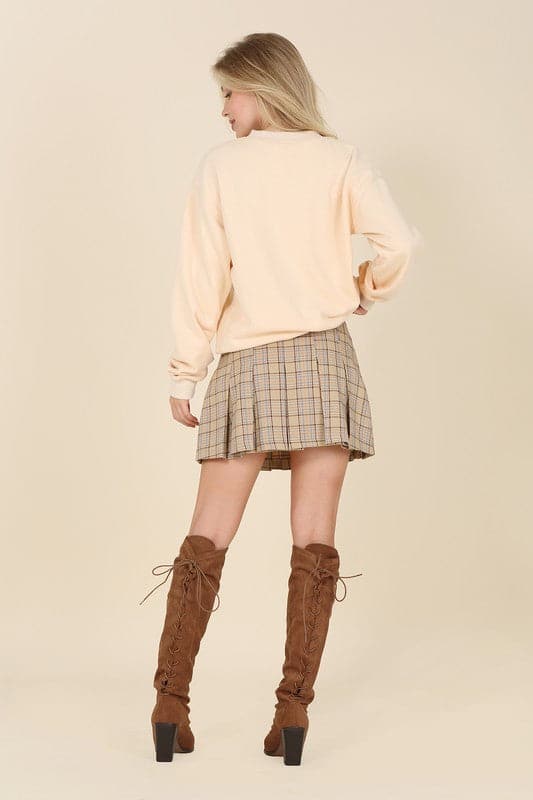 What fun fall will bring with the Baby Baby Plaid Pleated Mini Skirt! Features 6 pin tucks for each front and back and a side zipper. Style with a blouse or sweater with knee high boots, loafers or heels for a fun on trend fall look.  