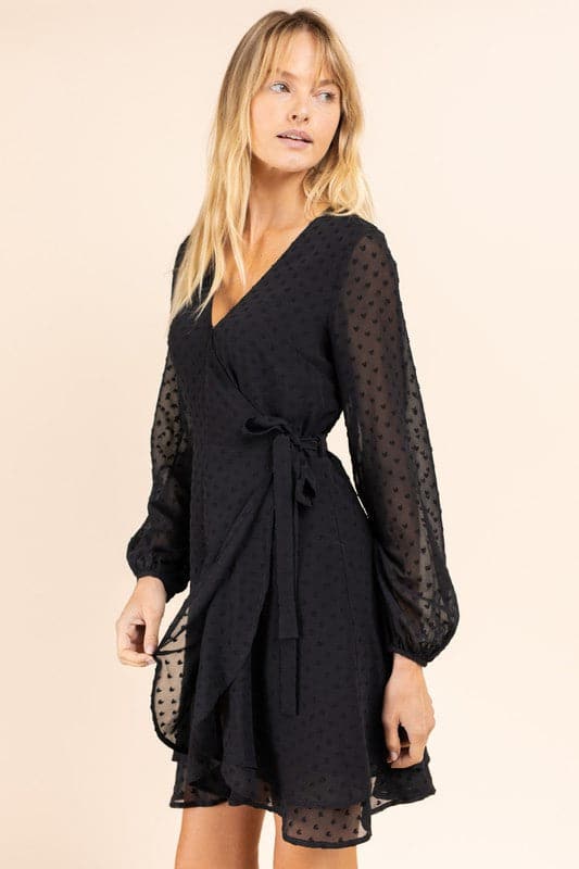 Sheer sleeves, a double layer skirt and a wrap front make this dress the perfect cocktail dress! Wear with some strappy heels and a chic clutch and you’re ready for any special occasion. Avah Couture