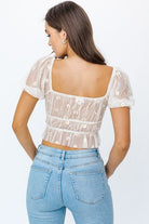 Avah Couture- Easy to throw on, this cute top is your new go-to! Perfect for a spring picnic with friends or a lunch date. This semi-sheer top features a delicate embroidered daisy flower, puff sleeves, and tie detail at the front. Pair it with jeans, shorts, or your favorite trouser pants.  Embroidery Floral Sheer Sweetheart neckline Short sleeve Puff sleeve Ruched Tie detail Cropped length- Ivory Yellow Floral