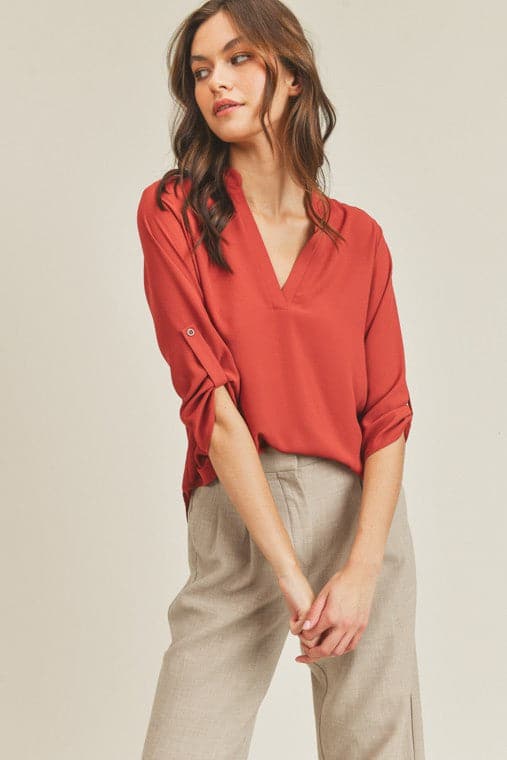 A chic, casual and stylish top. The simple v neck and high low hem add a trendy touch to this top. Wear it with jeans or skirt for a fall casual look or dress it up for work by pairing it with a pencil skirt or slacks. This v neck top is the ultimate staple piece in any wardrobe. Features v neckline, high low hem and roll up button quarter sleeve.  V-neckline Avah Couture