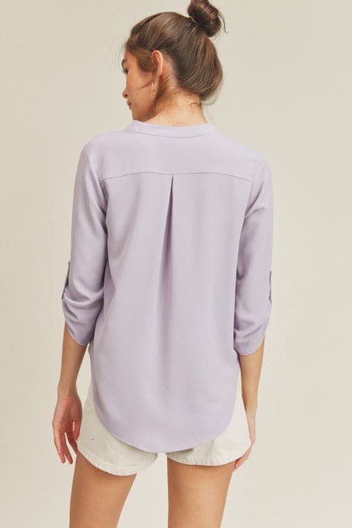 A chic, casual and stylish top. The simple v neck and high low hem add a trendy touch to this top. Wear it with jeans or skirt for a fall casual look or dress it up for work by pairing it with a pencil skirt or slacks. This v neck top is the ultimate staple piece in any wardrobe. Features v neckline, high low hem and roll up button quarter sleeve.  V-neckline Avah Couture