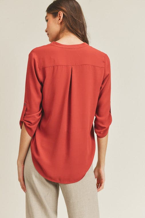 A chic, casual and stylish top. The simple v neck and high low hem add a trendy touch to this top. Wear it with jeans or skirt for a fall casual look or dress it up for work by pairing it with a pencil skirt or slacks. This v neck top is the ultimate staple piece in any wardrobe. Features v neckline, high low hem and roll up button quarter sleeve.  V-neckline Avah Couture