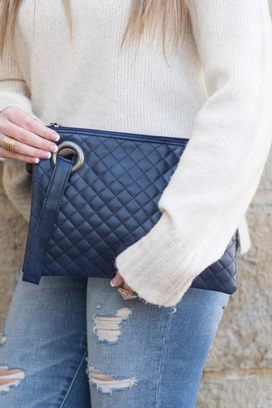 Classic and timeless, this beautifully quilted design clutch will be your go to bag. You’ll love it so much you’ll want one in every color! Made with a premium soft quilted PU leather and cotton Herringbone print lining and complete with grommet detail and wristlet. Avah Couture