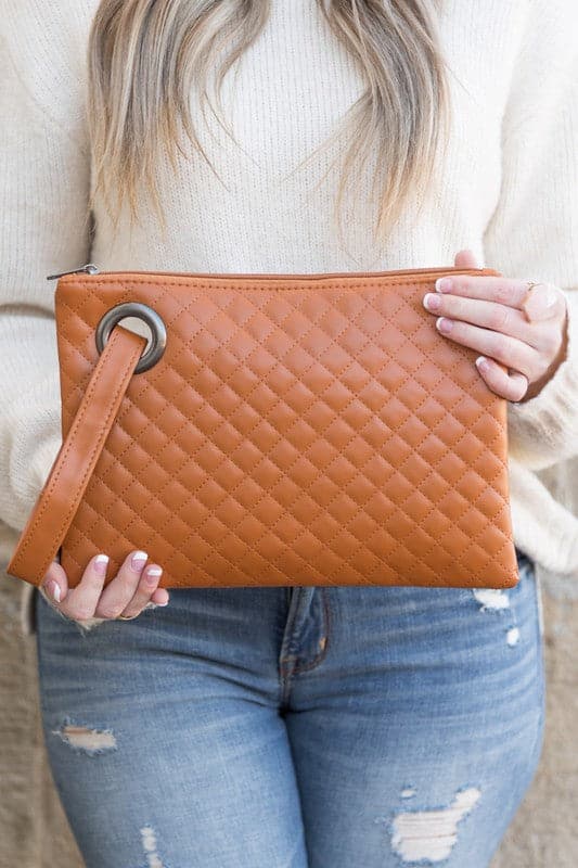 Classic and timeless, this beautifully quilted design clutch will be your go to bag. You’ll love it so much you’ll want one in every color! Made with a premium soft quilted PU leather and cotton Herringbone print lining and complete with grommet detail and wristlet. Avah Couture