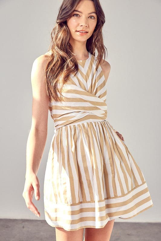 This striped mini dress will be your go to style for all seasons. The front cross and back tie create an easy fit and a flattering silhouette, while the pockets add extra style points. This sleeveless design is great for work or play and easily dresses up with a blazer and heels or down with a cardigan and sandals. Avah Couture
