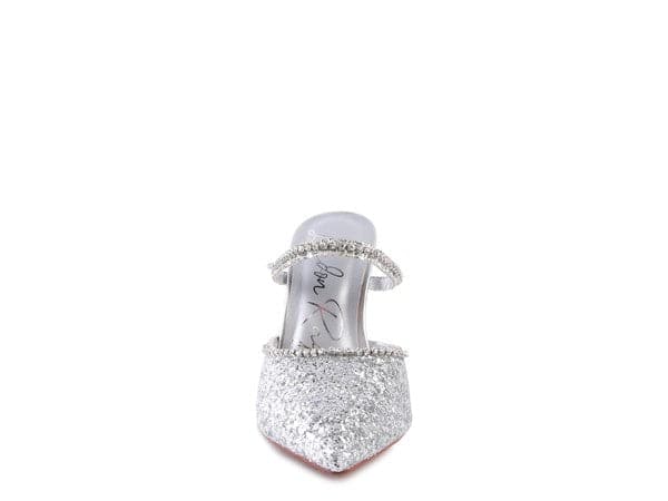 The perfect pair of silver glitter mules with rhinestone embellishment, designed to make you shine. Featuring a sculpted heel, pointed toe and crystal decorated elastic strap. Avah Couture