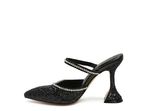 The perfect pair of glitter mules with rhinestone embellishment, designed to make you shine. Featuring a sculpted heel, pointed toe and crystal decorated elastic strap. Avah Couture