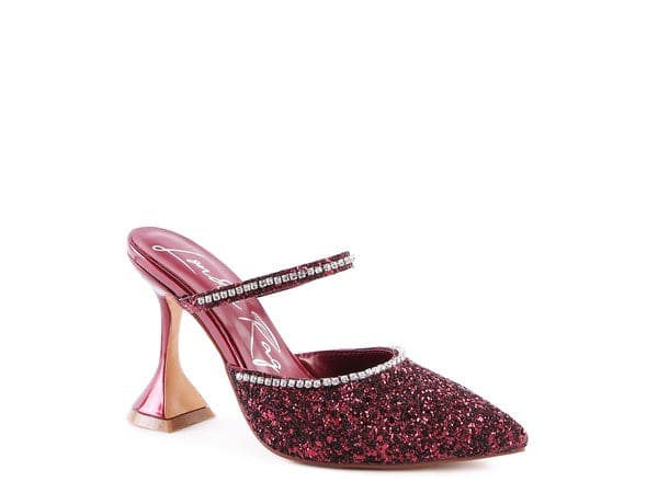 The perfect pair of red glitter mules with rhinestone embellishment, designed to make you shine. Featuring a sculpted heel, pointed toe and crystal decorated elastic strap. Avah Couture