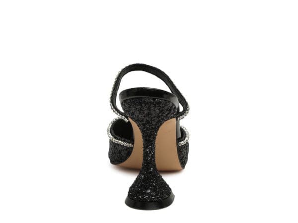 The perfect pair of glitter mules with rhinestone embellishment, designed to make you shine. Featuring a sculpted heel, pointed toe and crystal decorated elastic strap. Avah Couture